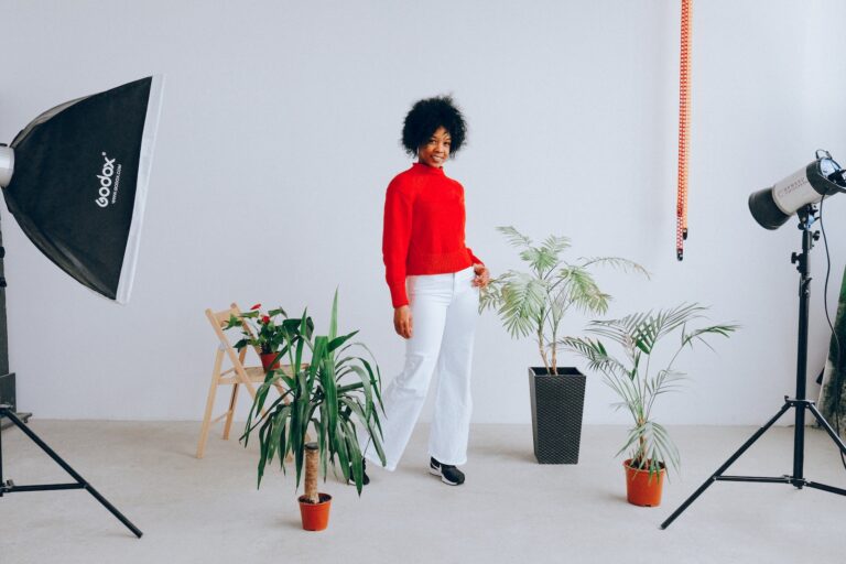 Smiling ethnic woman having photo session with plants