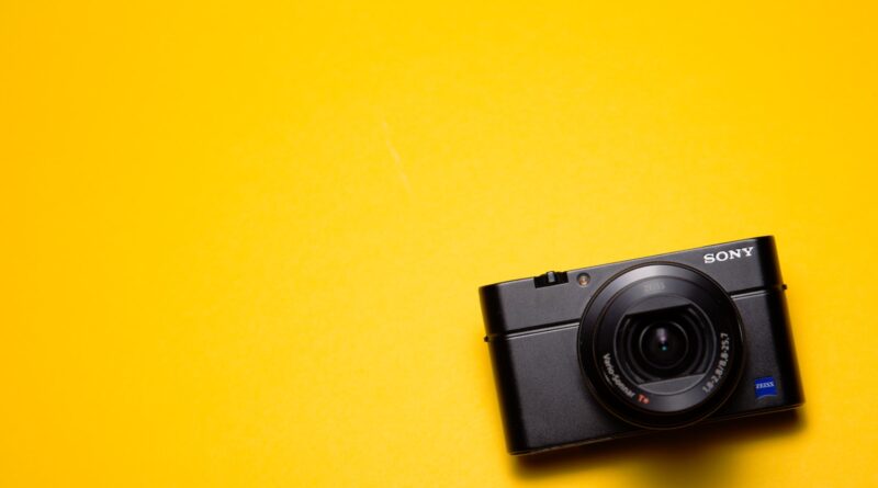 black Sony point-and-shoot camera on yellow surface